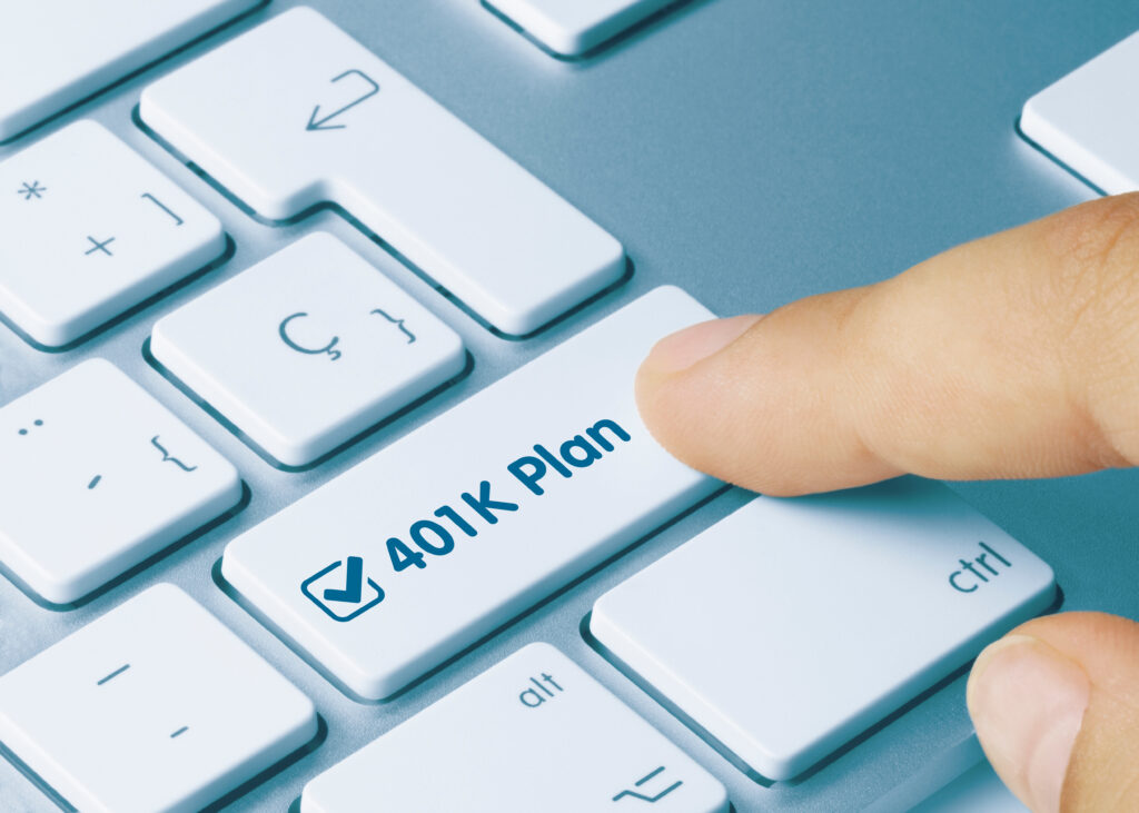 finger pressing a button on a computer that says 401k plan