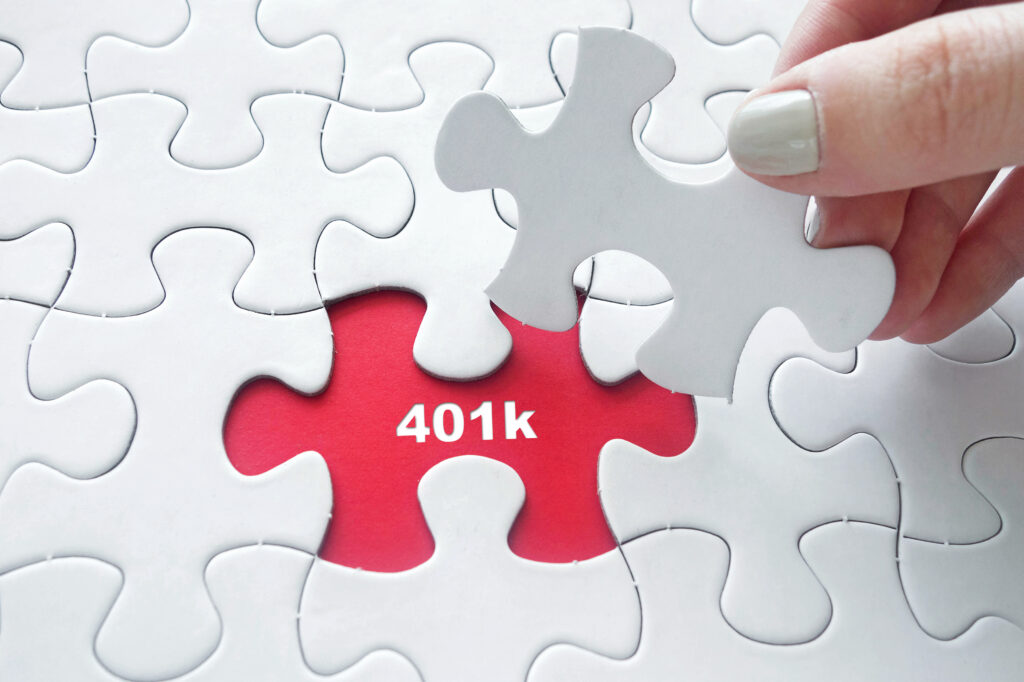 Hand placing jigsaw puzzle with 401k text
