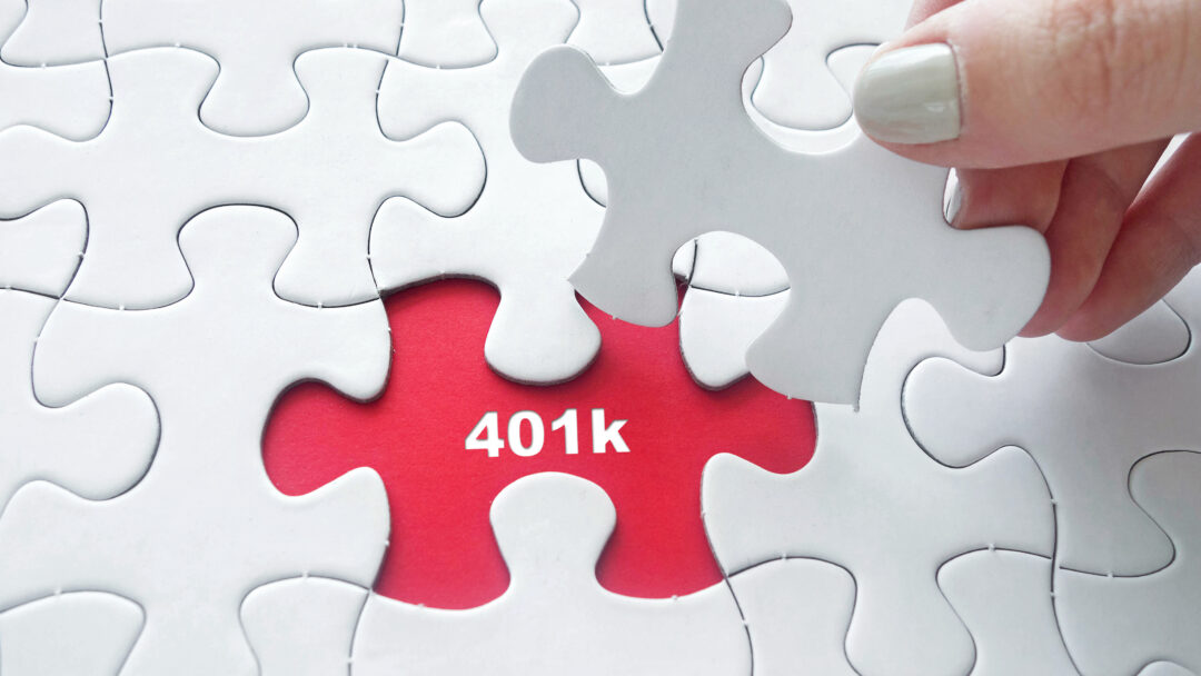 Hand placing jigsaw puzzle with 401k text