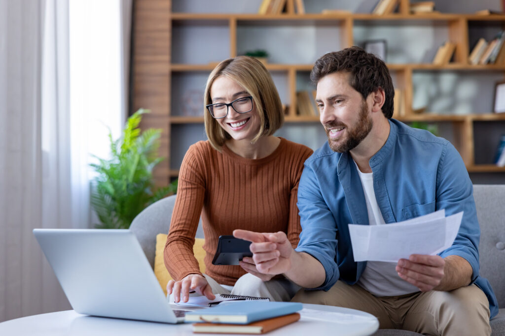 Couple managing home budget and finances using laptop
