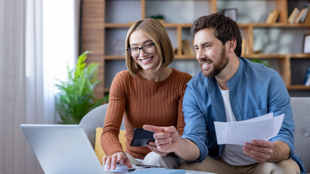 Couple managing home budget and finances using laptop