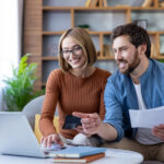 Couple managing home budget and finances using laptop