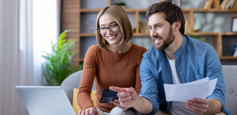 Couple managing home budget and finances using laptop