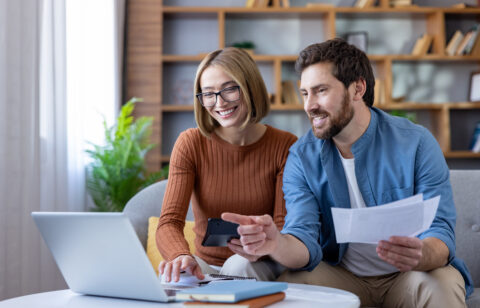 Couple managing home budget and finances using laptop