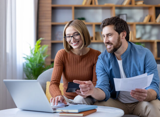 Couple managing home budget and finances using laptop