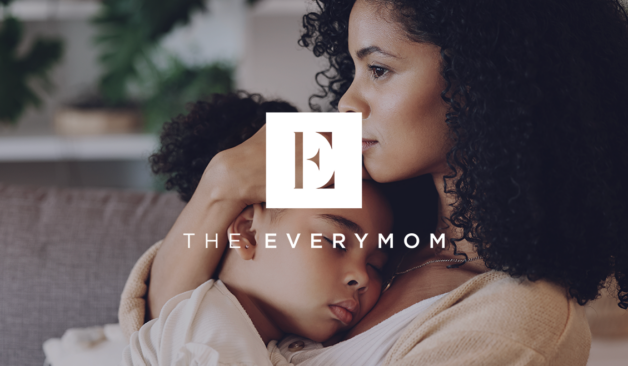 Mom holding her young daughter with The Everymom logo layered on top.