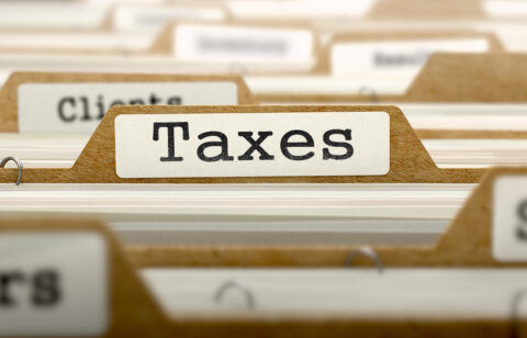 Taxes Concept with Word on Folder.