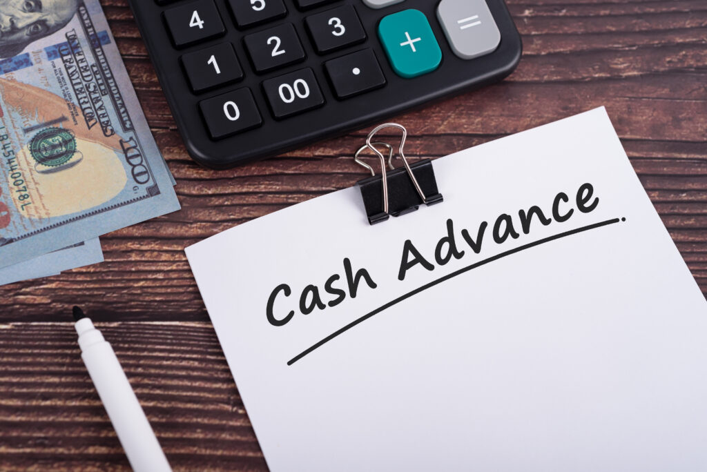 Cash advance text on white paper with calculator and US dollar