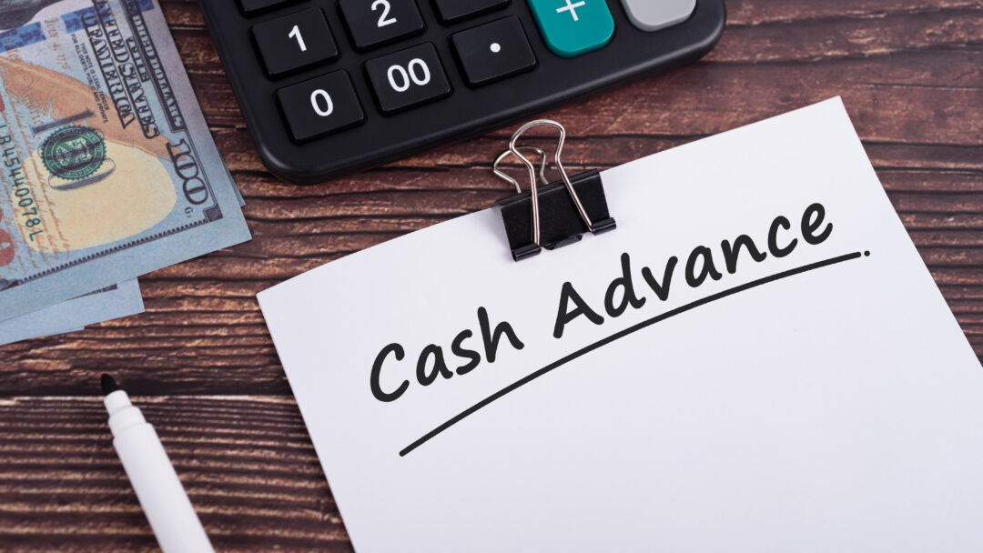 Cash advance text on white paper with calculator and US dollar