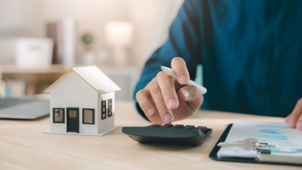 Mortgage loan interest rate payment signing real estate model planning property investment handled by expert using calculator with house keys and documents for home finance purchase deal