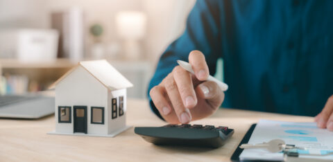 Mortgage loan interest rate payment signing real estate model planning property investment handled by expert using calculator with house keys and documents for home finance purchase deal