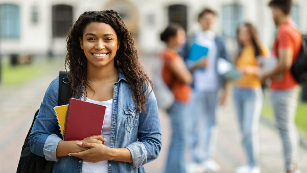 Loans for education concept. Portrait of happy black female student posing outdoors