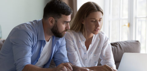 Couple reviewing their finances together on a laptop at home.